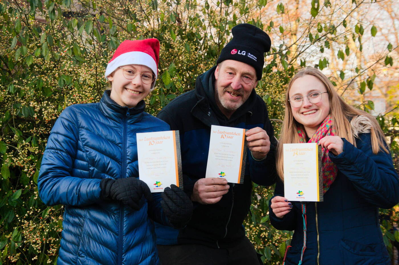 De drie vrijwilligers die vnlr een 10-jaar, 10-jaar en een 15-jaar jubileum ereteken ontvingen bij de Scouting Tono-groep Schiedam